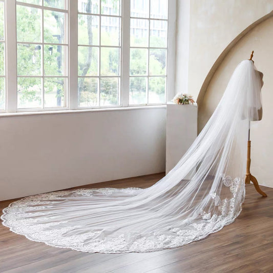 Bride wearing a long cathedral wedding veil with an elegant wedding dress
