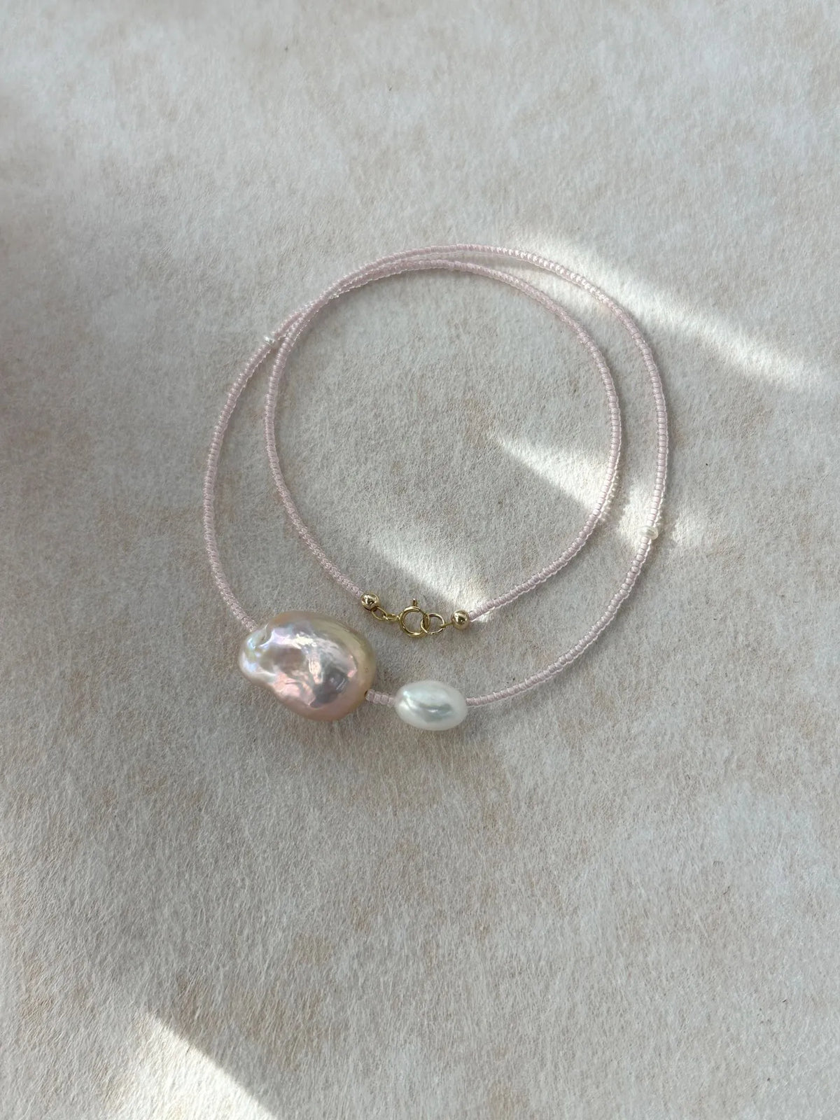 Loop display of the fairy pink pearl necklace showcasing the 14K gold filled clasp.