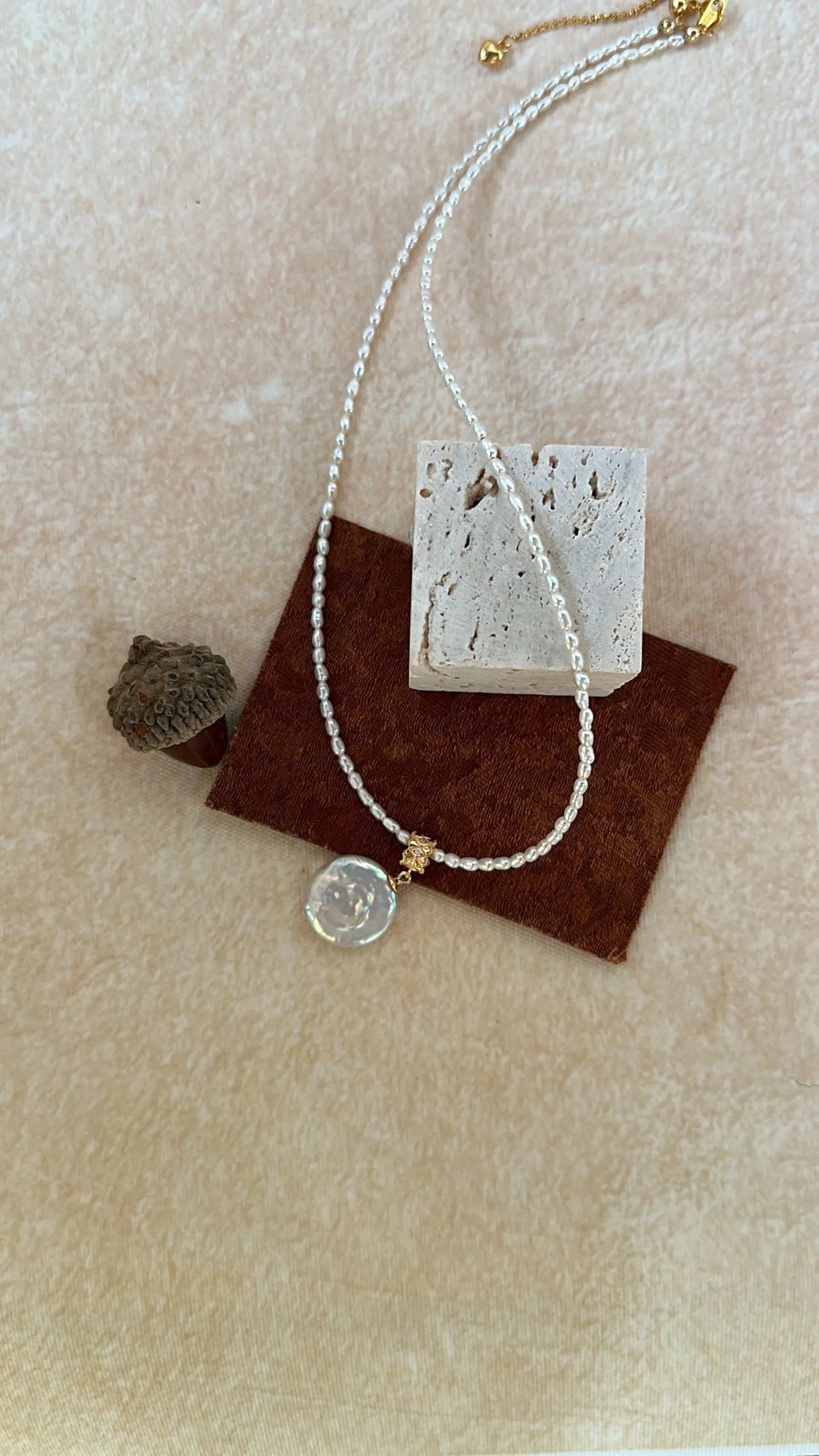 Coiled Roman pearl necklace showing the 14K gold-filled clasp and extension chain.