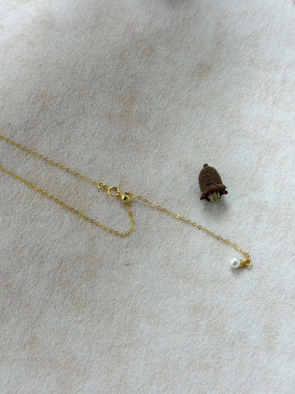 Detailed view of 14K gold-filled silicone slider bead mechanism with mini pearl tail.