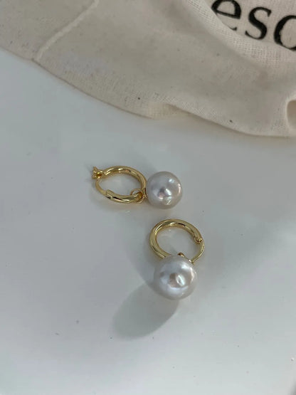Angled display of the 18k gold-plated crystal baroque pearl drop earrings highlighting the hoop clasp and luster.