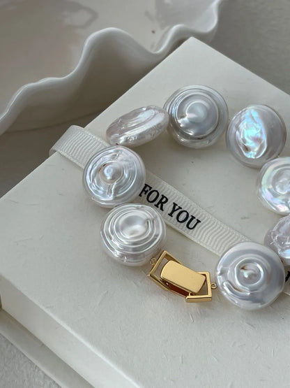 Close-up view of the 18k gold-plated rectangular box clasp on the coin baroque pearl strand.