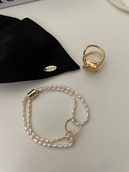 Overhead shot of the fine freshwater seed pearl bracelet highlighting interlocked 18k gold plated rings.