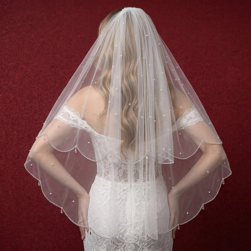 Rear three-quarter angle of bride showcasing 2-tier veil drape over off-the-shoulder lace corset gown