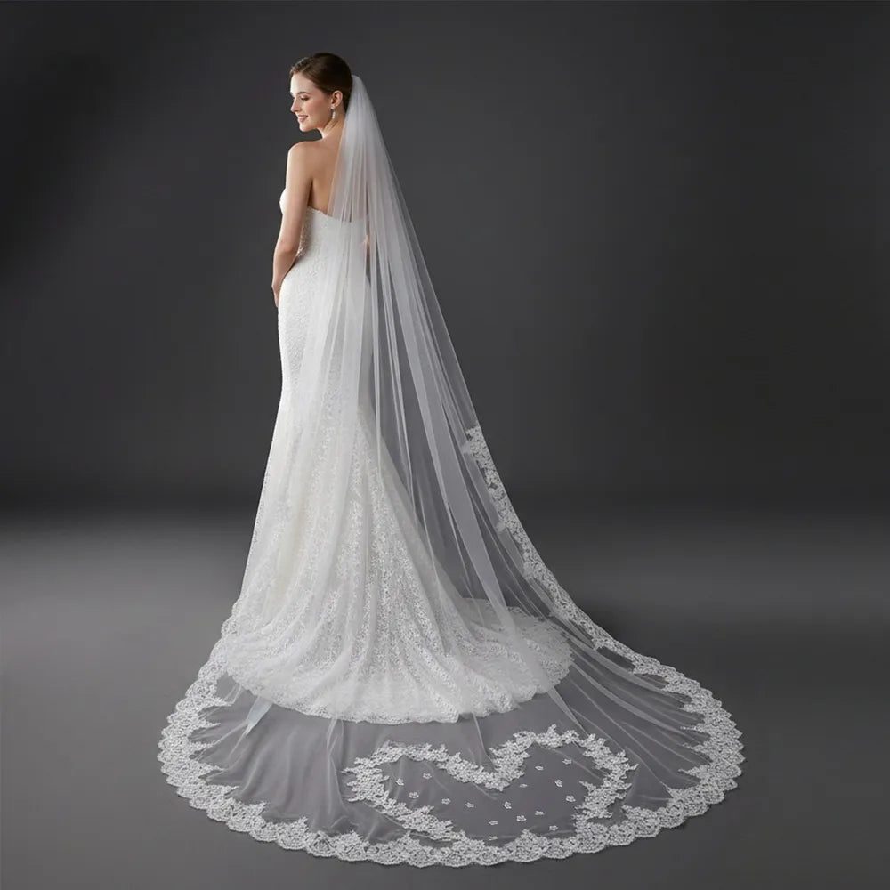 Full-length rear shot of bride with lace veil cascading past mermaid dress train