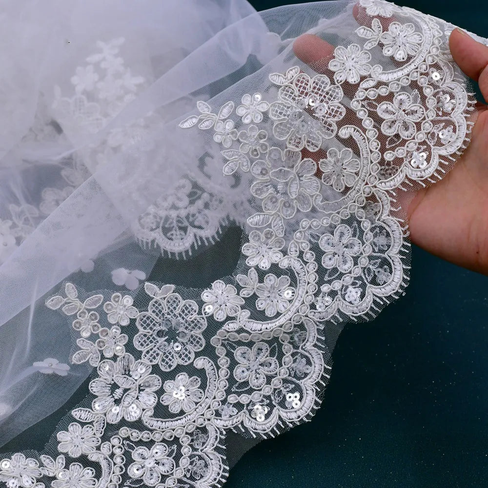 Detailed close-up shot showing delicate sequins and floral embroidery stitched along the wide scalloped hem