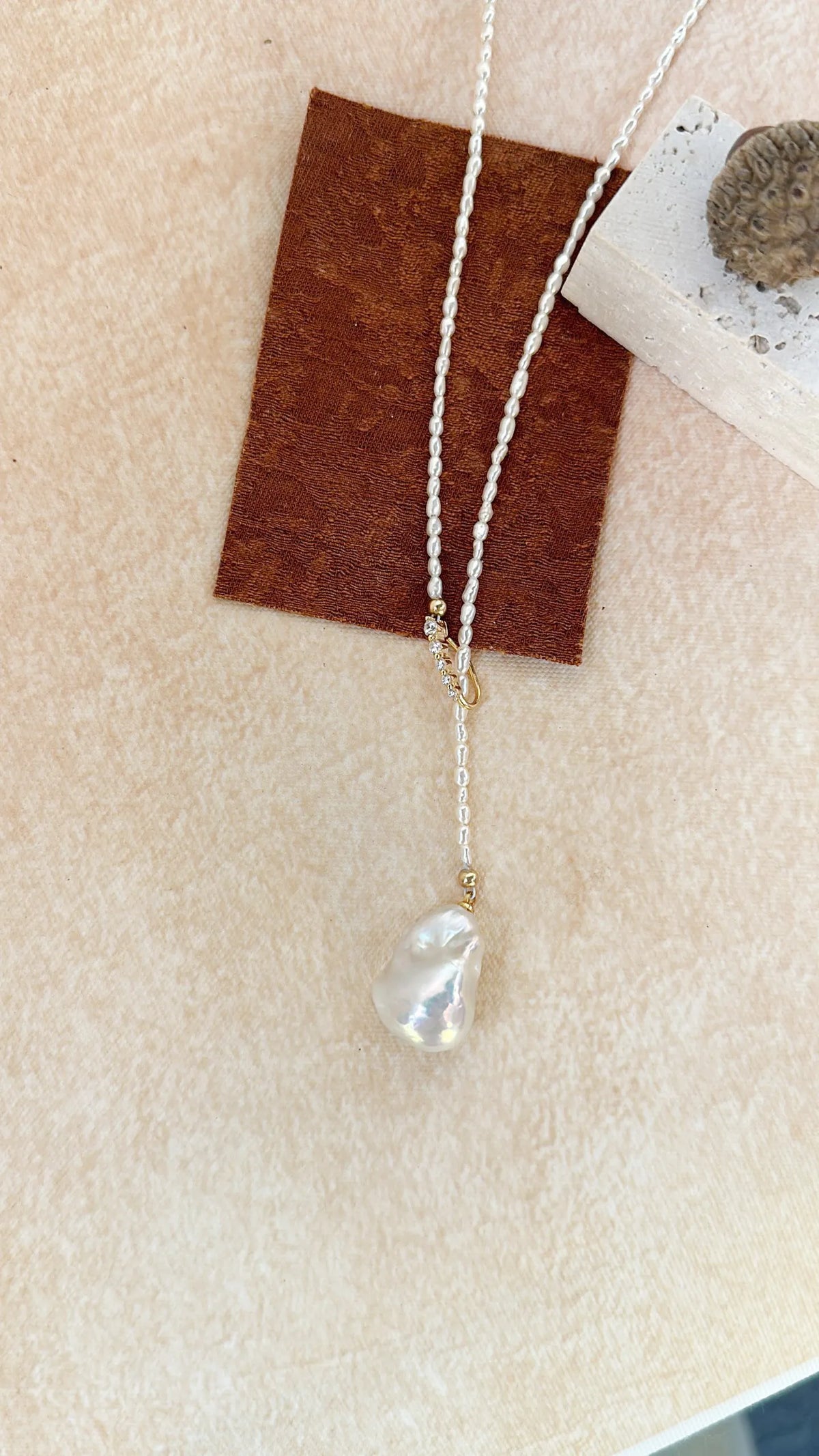 Coiled 65cm Keshi pearl strand showing full length and slider position.