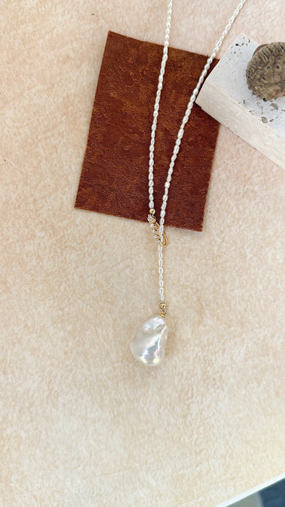 Coiled 65cm Keshi pearl strand showing full length and slider position.