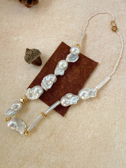 Detailed close-up of the 925 sterling silver 18k gold-plated lobster clasp and seed pearl backing.
