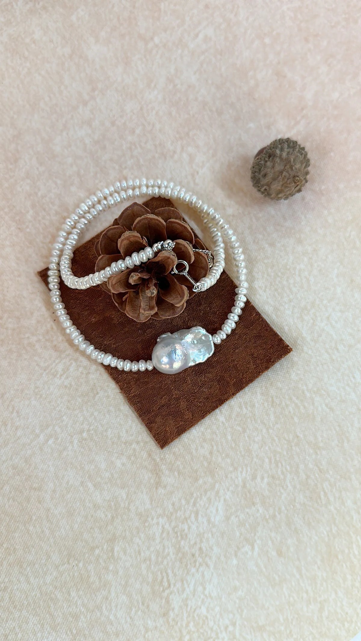 Coiled pearl necklace showing the 925 sterling silver clasp and seed pearl strand.