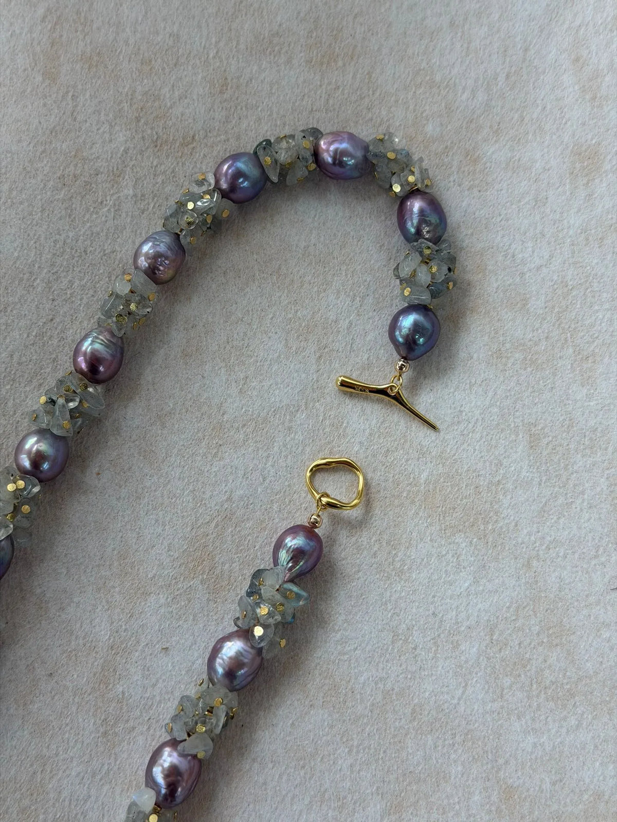 Close-up view of 18K gold-plated S925 OT toggle clasp on moonstone pearl necklace.