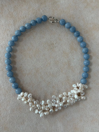 Overhead flatlay view showing the complete shape of the angelite gemstone and clustered baroque pearl necklace.