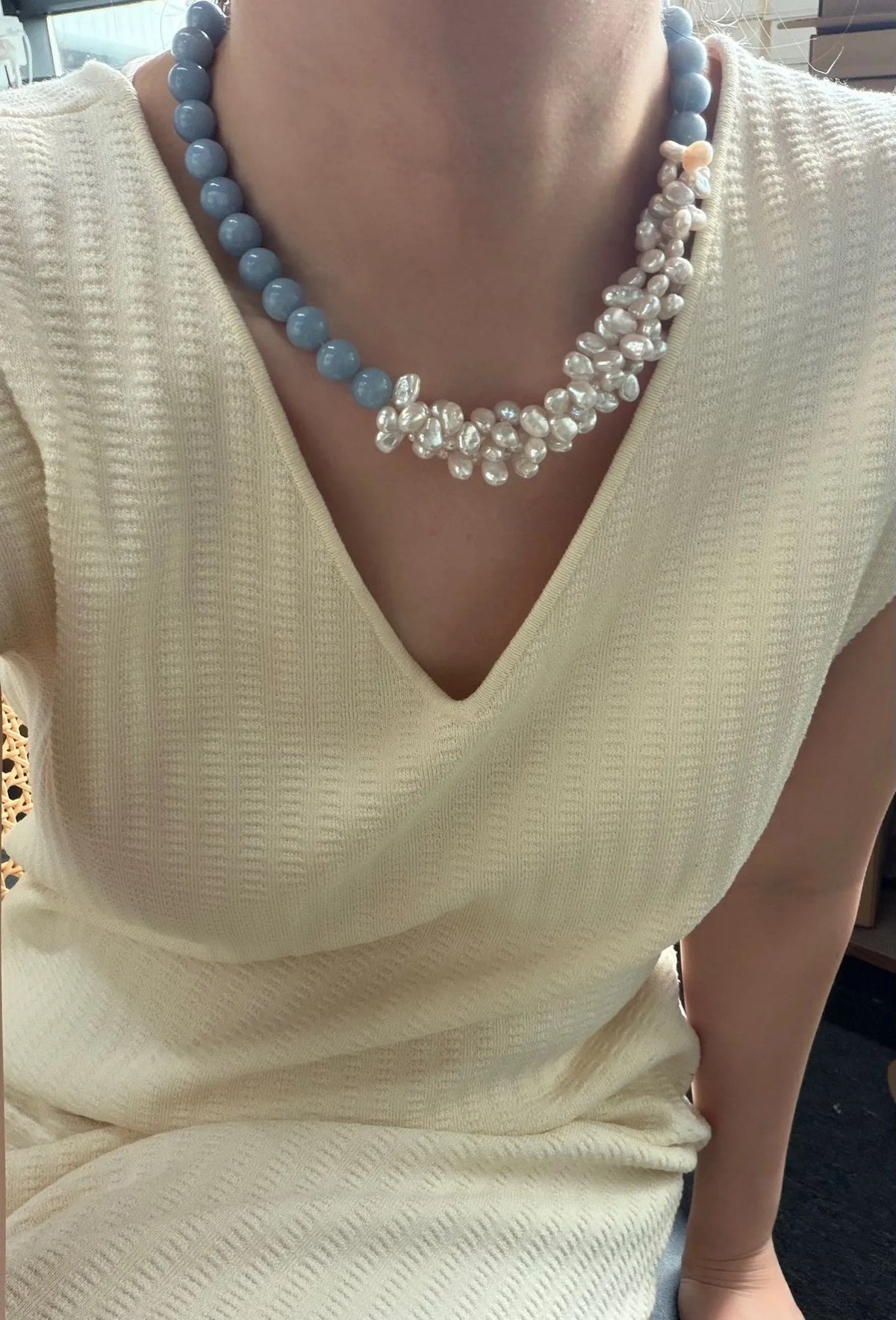 Model wearing the 43cm soft blue angelite and clustered white pearl necklace with a V-neck sweater.
