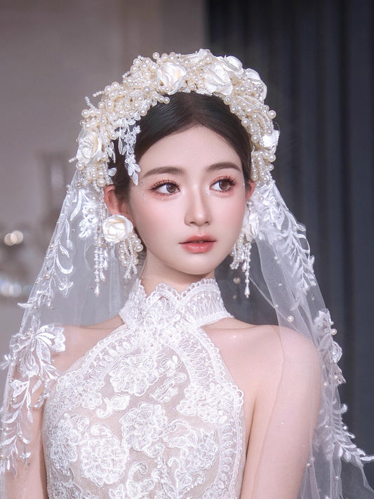 Baroque style luxury bridal headpiece set featuring a high-volume clustered pearl headband with satin silk roses and matching beaded tassel drop ear-pieces in creamy ivory.