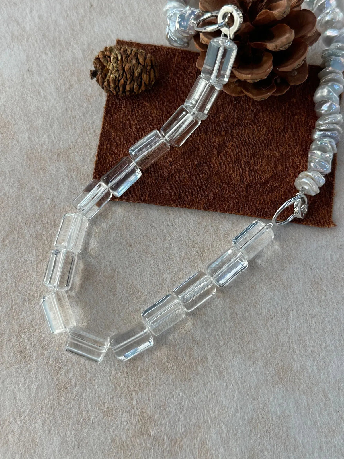 Macro shot of the S925 sterling silver dual spring clasp connecting pearl and crystal strands.