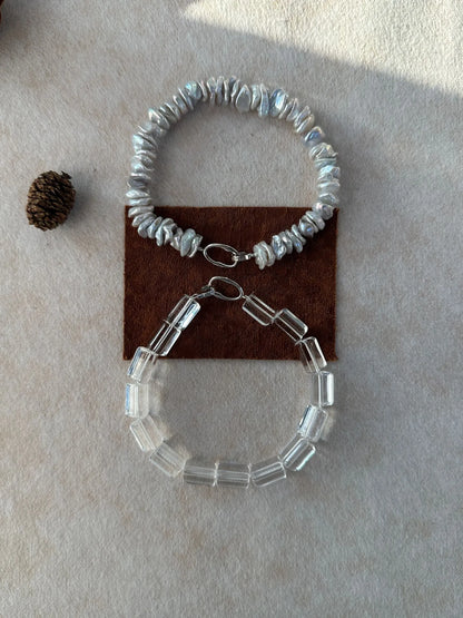 Convertible baroque pearl and clear crystal bracelet set shown on fabric background.