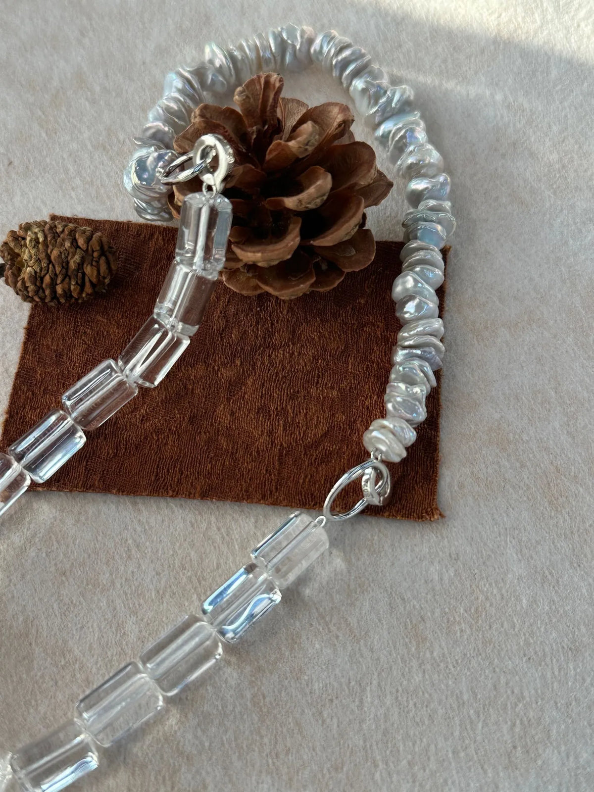 Convertible baroque pearl and clear crystal bracelet set shown on fabric background.