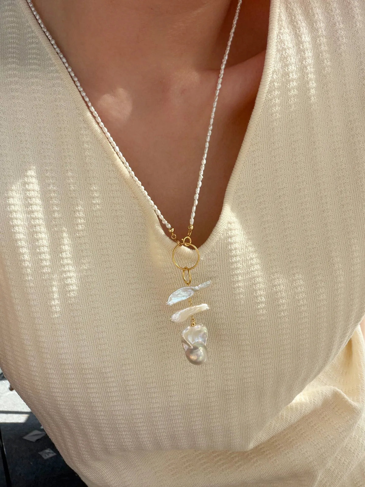 Model wearing the 50cm geometric double ring baroque pearl necklace with a cream knit top.