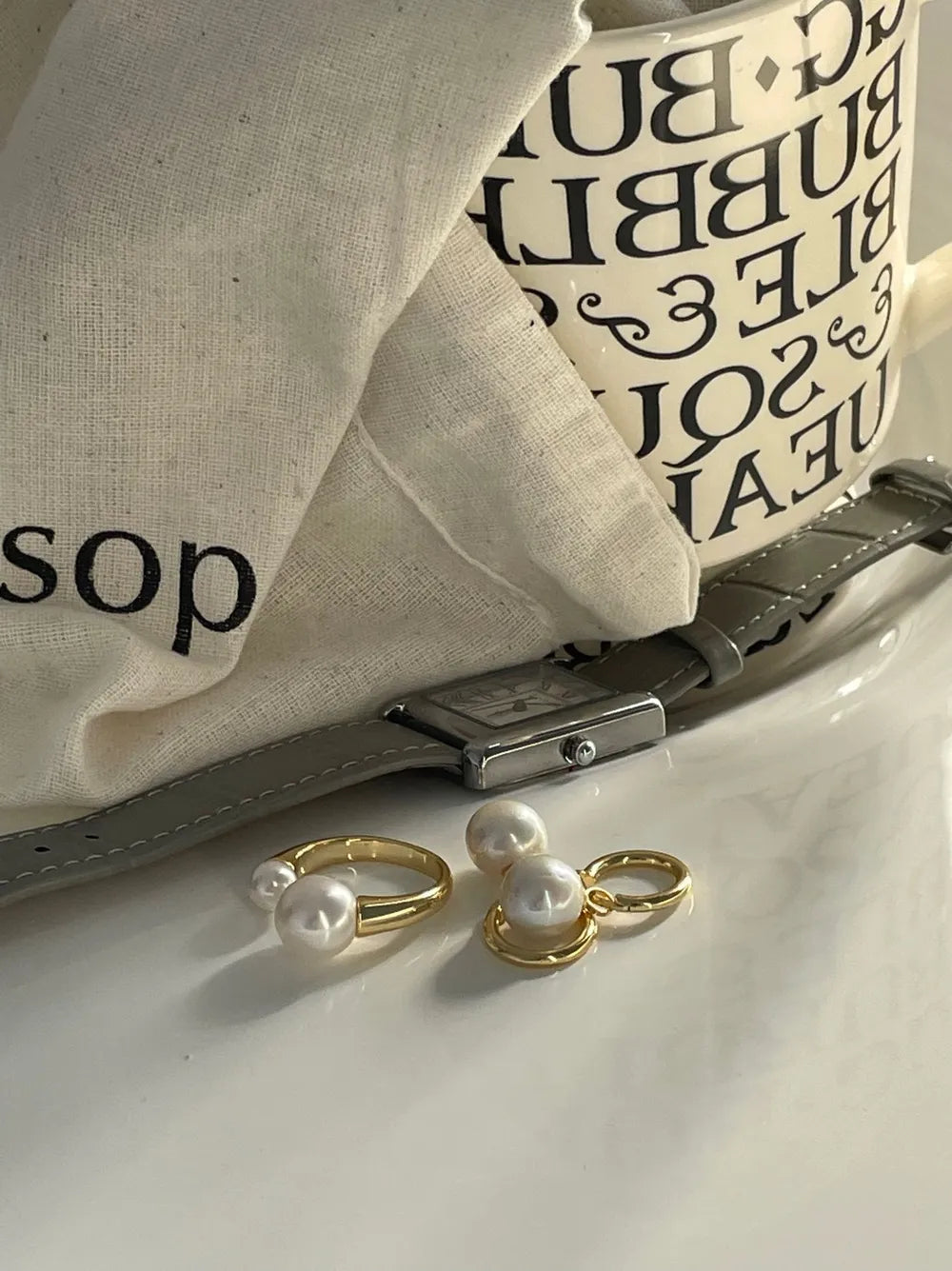 Crystal baroque pearl huggie earrings shown together with a matching gold pearl ring set.