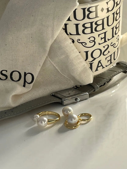 Crystal baroque pearl huggie earrings shown together with a matching gold pearl ring set.