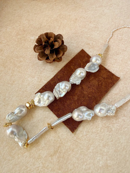 Close-up of natural organic baroque pearls, stick pearls, and brass gold-plated accent beads.