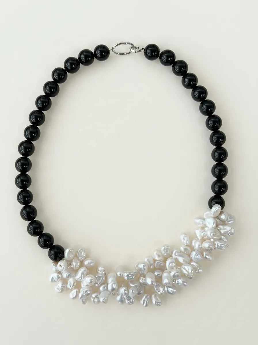 Full view flatlay of black agate and multi-layer white pearl cluster choker with S925 sterling silver clasp.