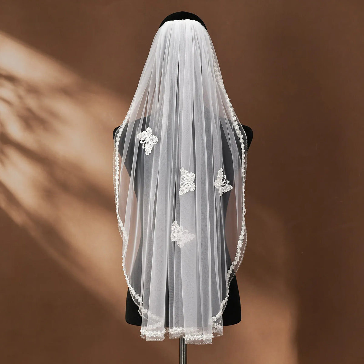Side profile of 90cm fingertip veil on mannequin displaying natural cascading folds and scalloped pearl edge