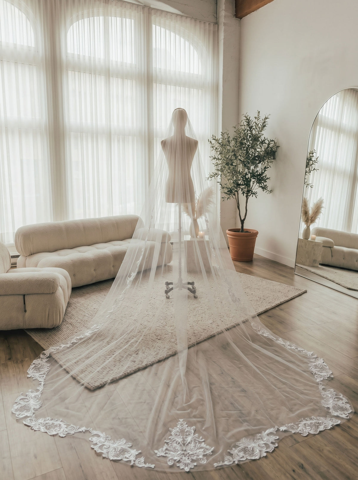 Mannequin display full circular lace trim cathedral veil with center floral lace applique