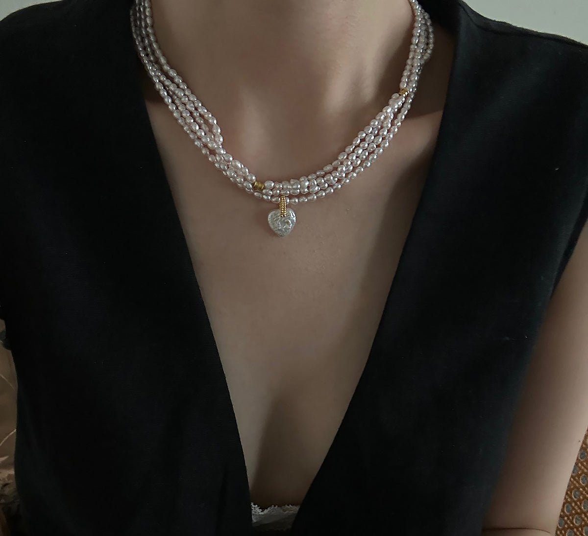 Close up of organic heart shaped baroque freshwater pearl pendant on seed pearl necklace