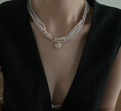 Close up of organic heart shaped baroque freshwater pearl pendant on seed pearl necklace