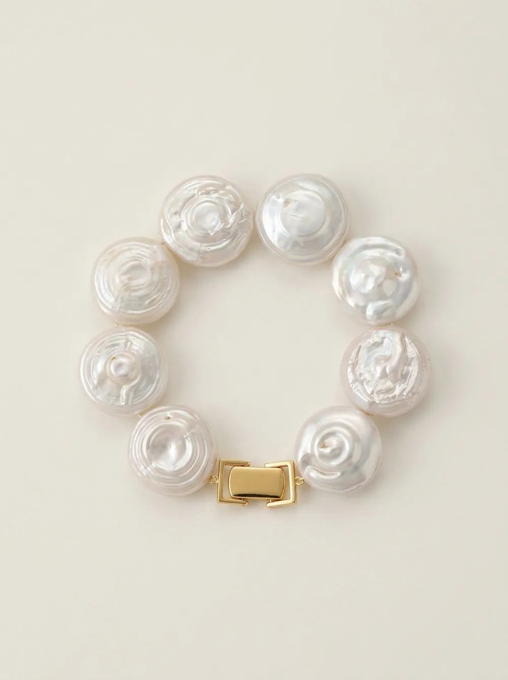 Flatlay view of the circular coin button baroque pearl bracelet with gold S925 silver box clasp.