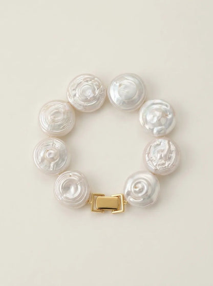 Flatlay view of the circular coin button baroque pearl bracelet with gold S925 silver box clasp.