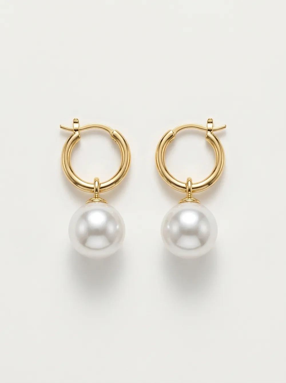 Front flatlay view of a pair of 18k gold-plated S925 sterling silver crystal baroque pearl huggie hoop earrings.