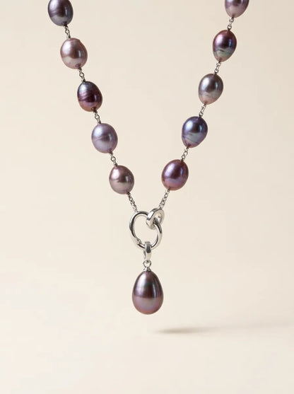 Floating studio shot of deep violet baroque pearl Y-lariat necklace highlighting S925 silver double-ring clasp and teardrop pearl pendant.