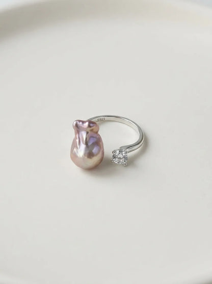 S925 sterling silver diamond bean baroque pearl open ring with cubic zirconia displayed on white ceramic plate.