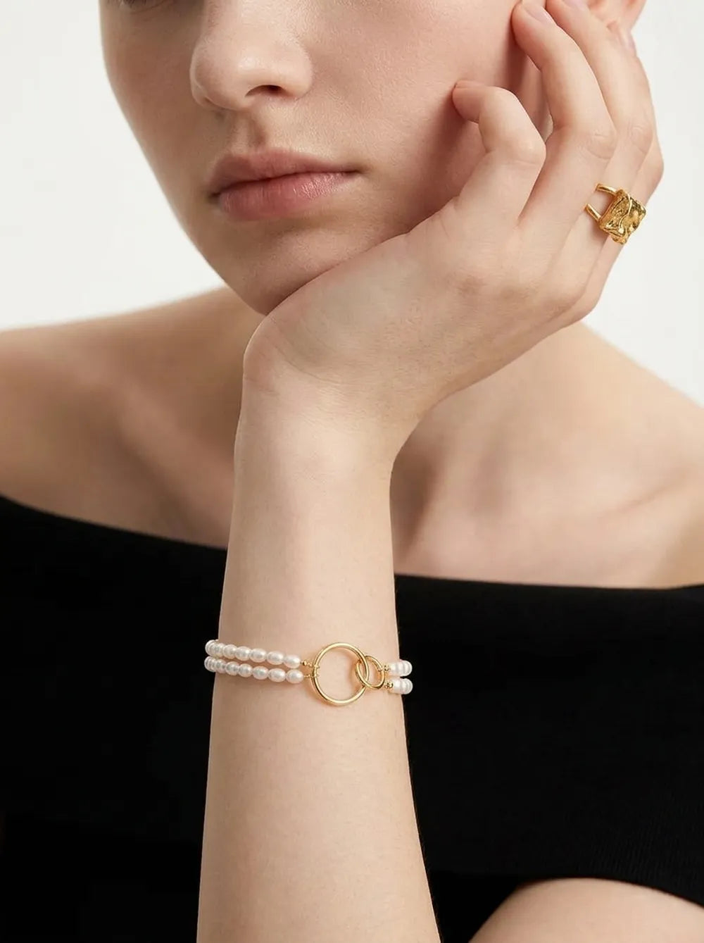 Model wearing the 18cm double circle seed pearl layered bracelet on wrist paired with an off-shoulder top.