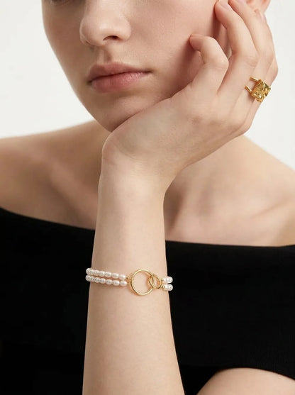 Model wearing the 18cm double circle seed pearl layered bracelet on wrist paired with an off-shoulder top.