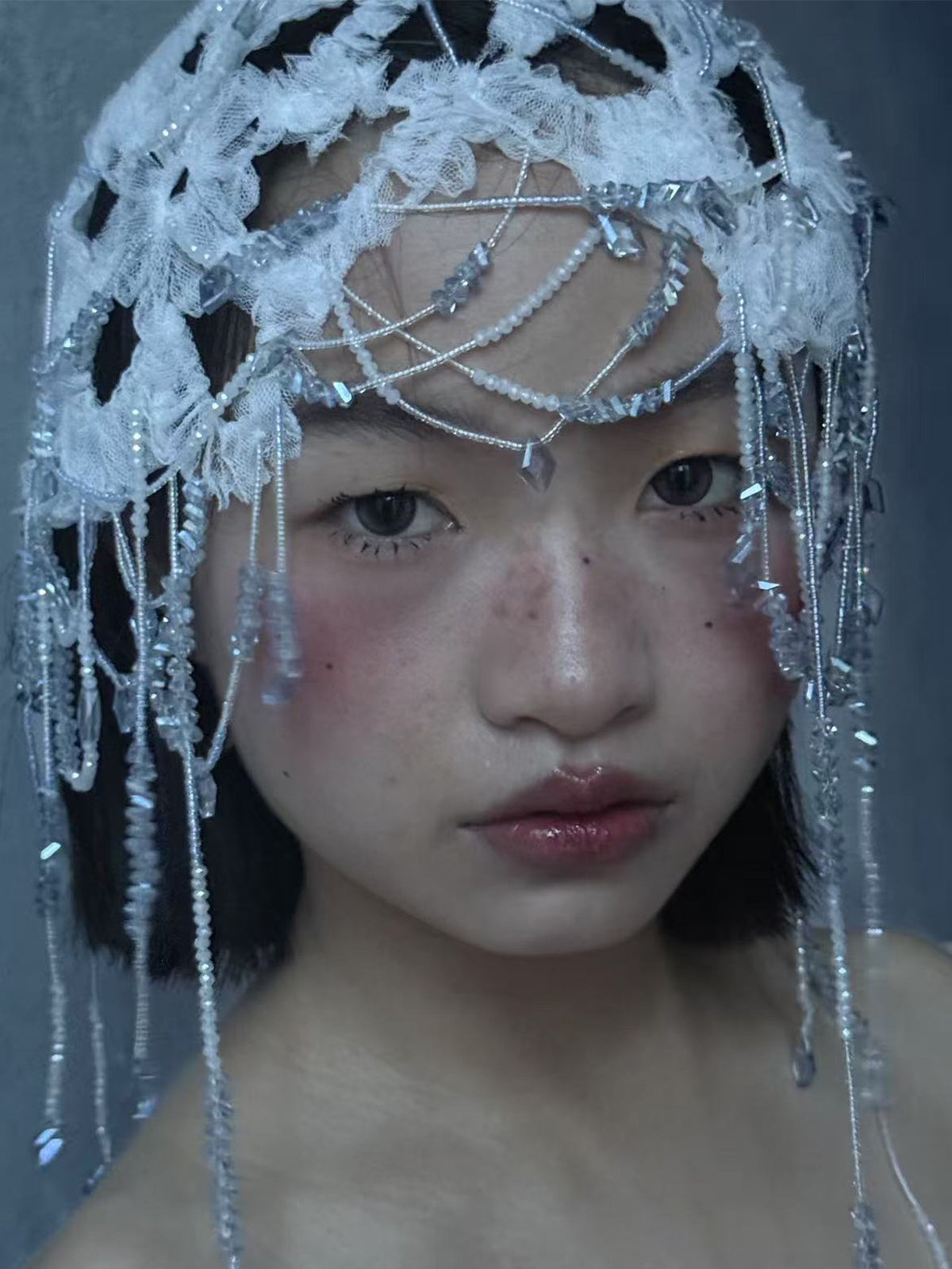 Fairy core bridal lace hair net and avant-garde Juliet cap featuring embroidered white floral lace, icy clear crystal beadwork, and layered cascading droplet strands.