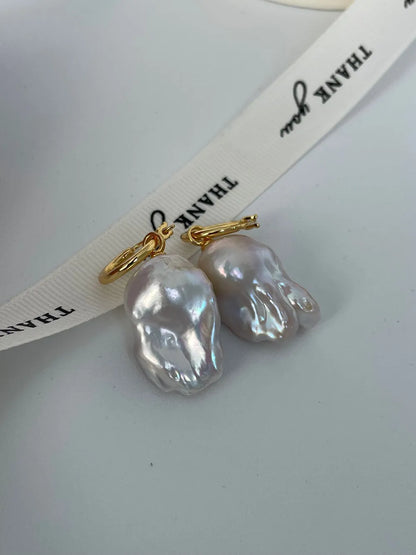 Close-up showing the unique flame tail surface texture and iridescent luster of baroque pearls.