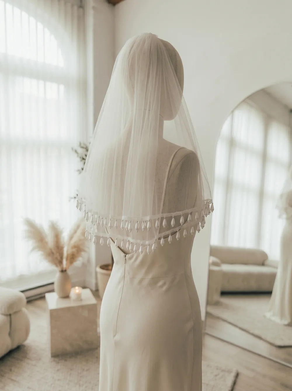Teardrop pearl tassel edge complementing a strapless satin corset wedding dress