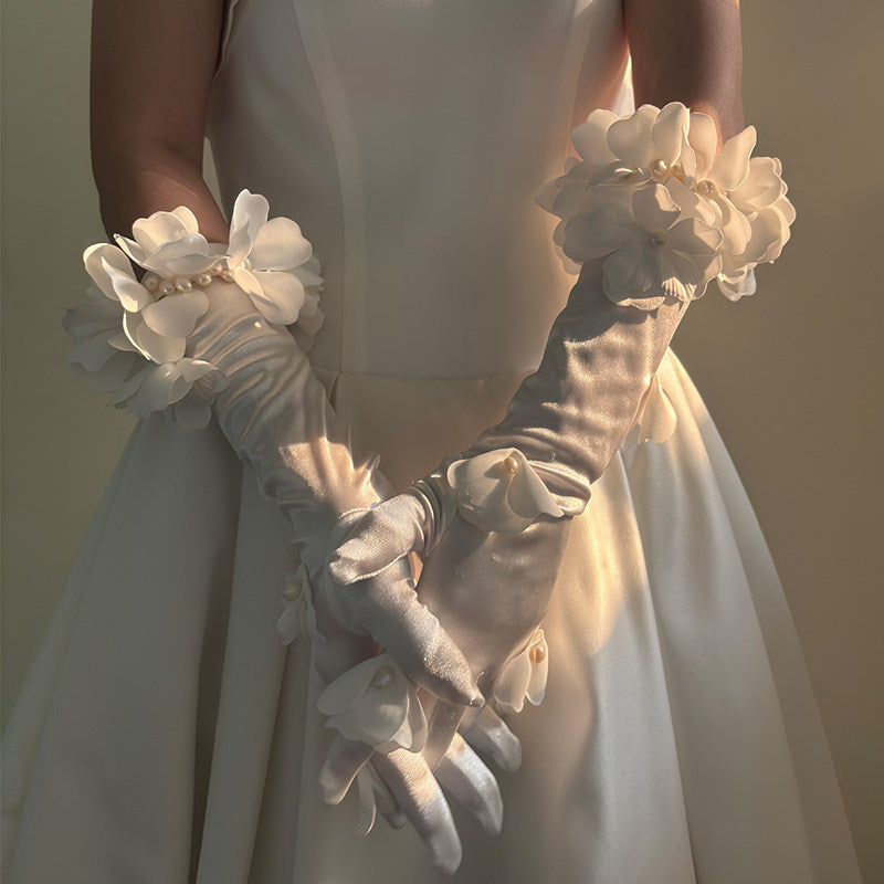 French romantic long ivory satin opera gloves with handcrafted 3D organza floral clusters and pearl petal embellishments for bridal wear.