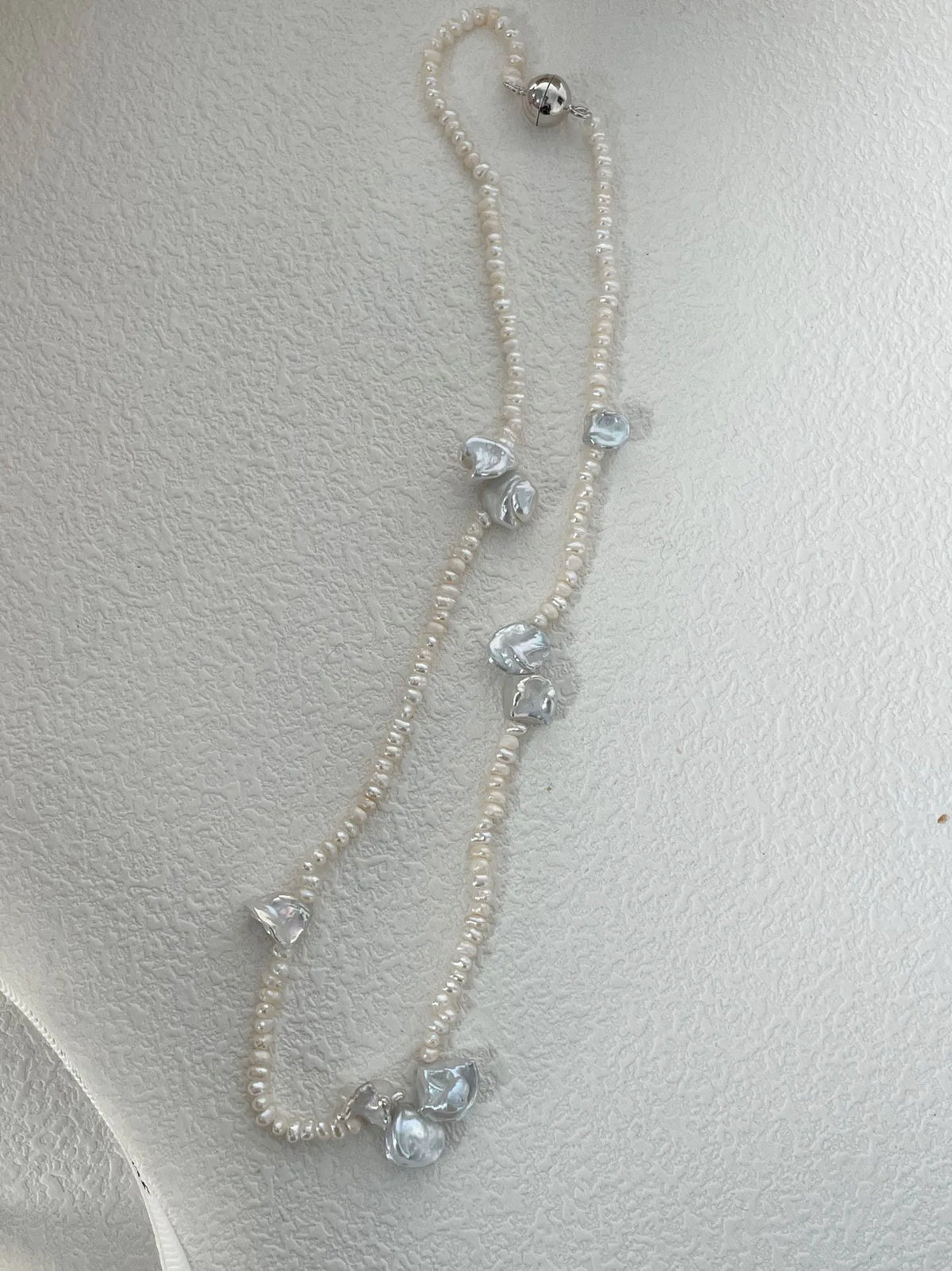 Full view of irregular petal freshwater pearl necklace showcasing the silver metallic magnetic clasp