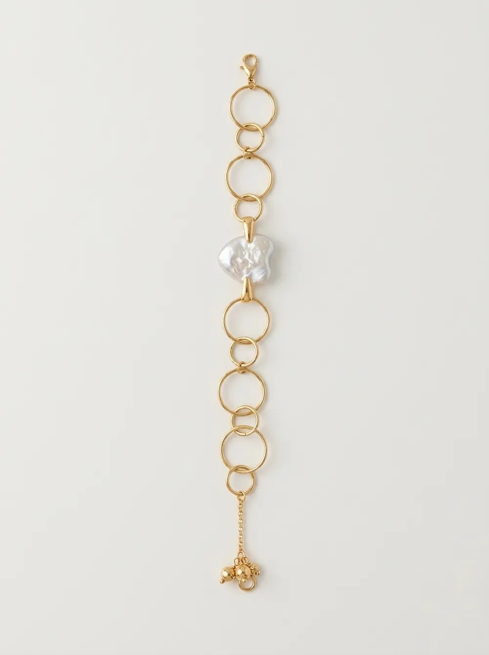 Flatlay view of the extended 18k gold-plated S925 silver geometric hoop heart baroque pearl bracelet.