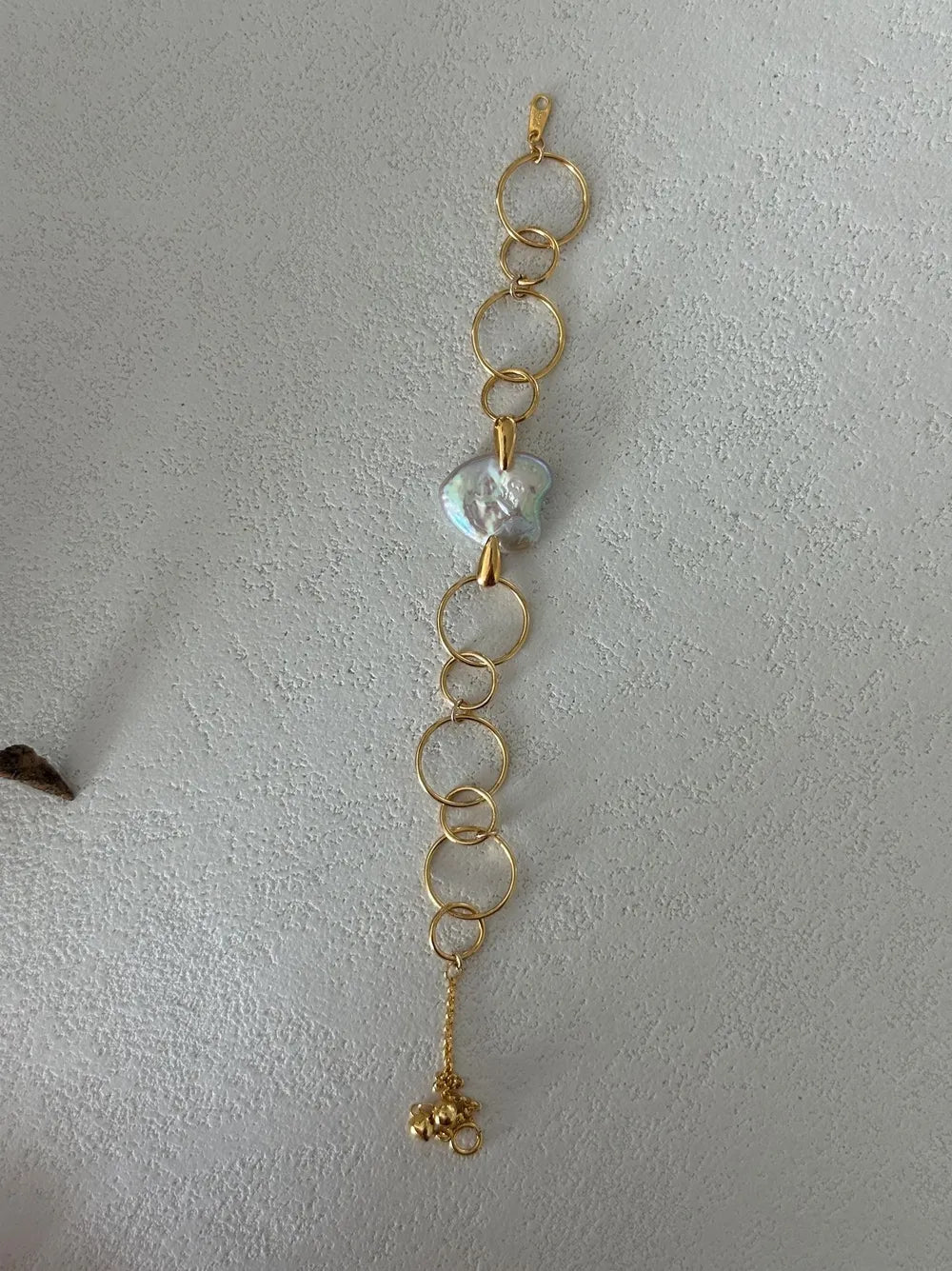  Geometric hoop heart baroque pearl bracelet displayed vertically on white textured background.   