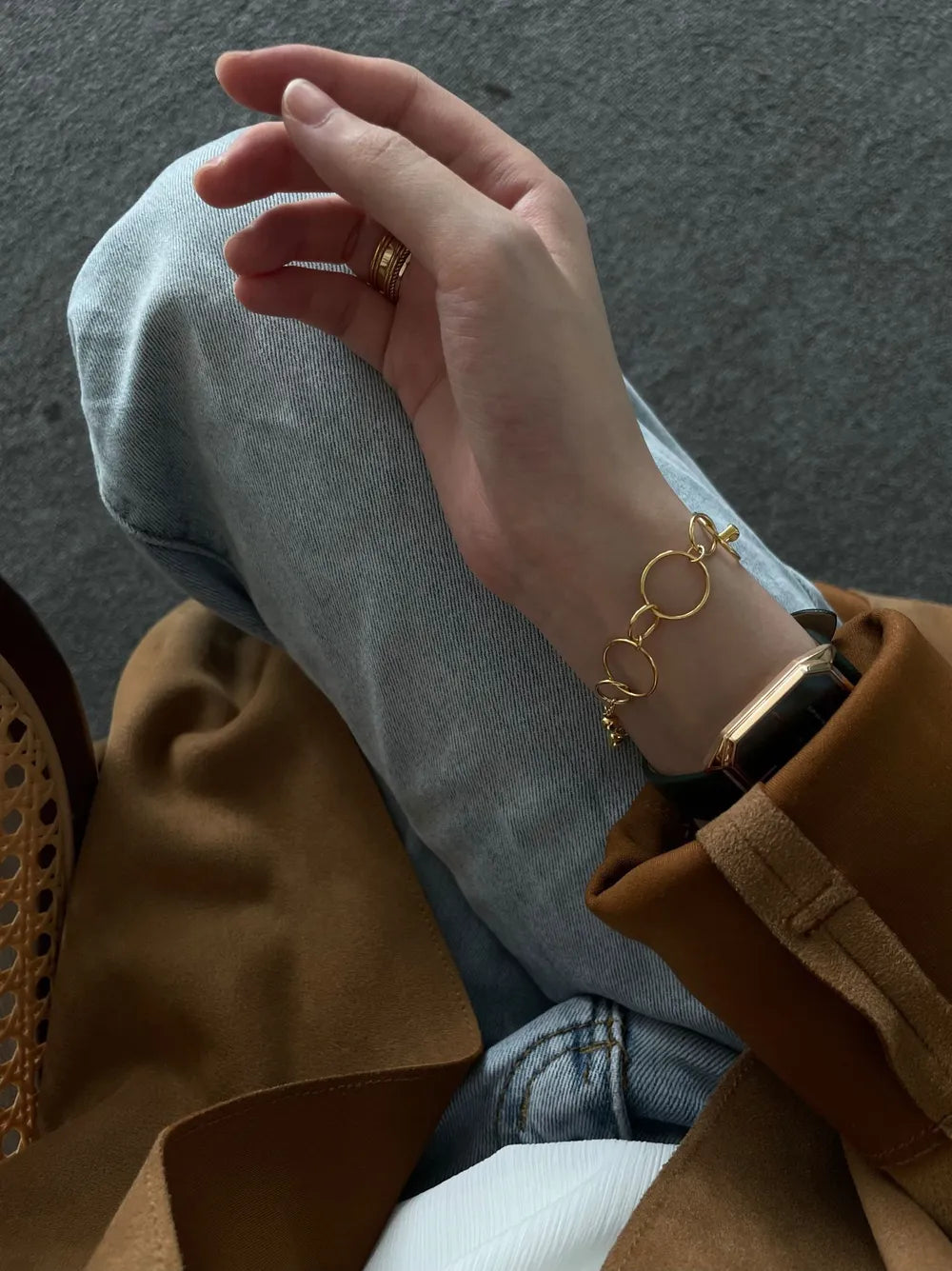 Geometric hoop pearl bracelet stacked alongside a square vintage gold wristwatch on model's wrist