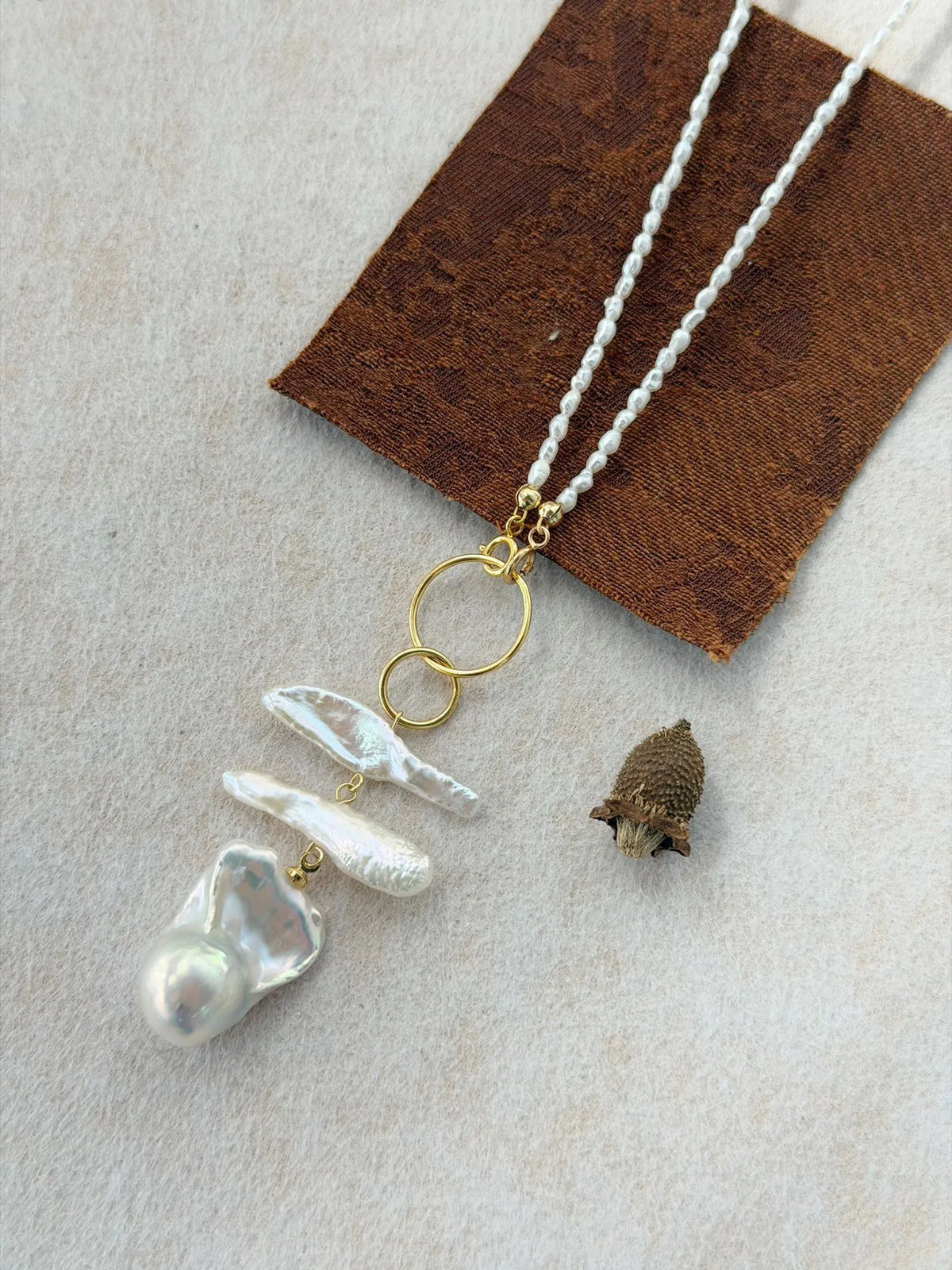 Detailed shot of the S925 gold-plated geometric double ring connector and clasp on the baroque pearl necklace.