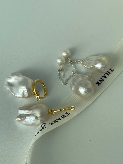 Group shot showing gold huggie hoop and silver long chain baroque pearl earrings.