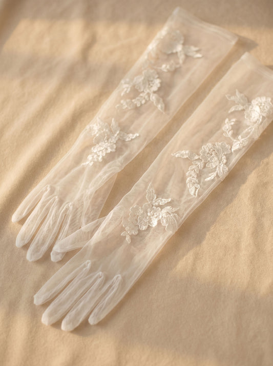 Dramatic 70cm off-white anti-wrinkle mesh bridal gloves with French ruched folds and floating botanical lace embroidery.