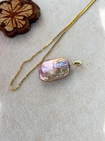 Macro shot showing rainbow luster of square baroque pearl and 18K gold-plated box chain.