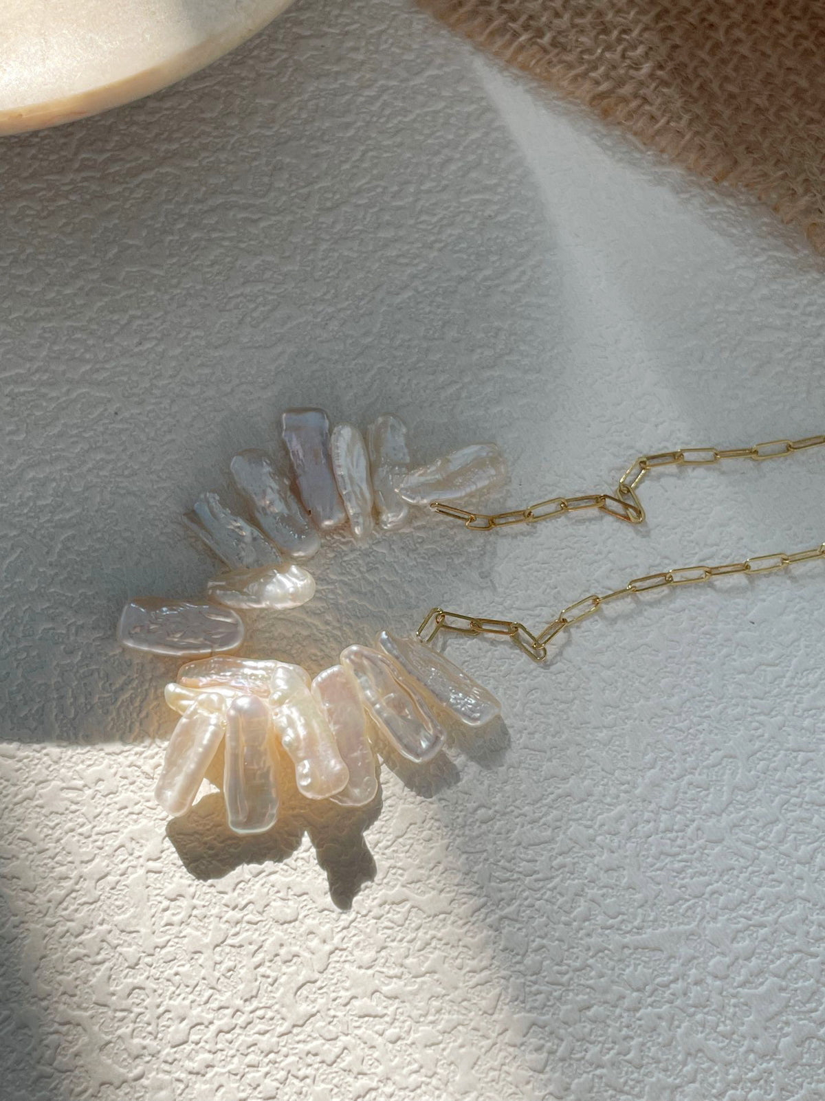 Close-up of naturally irregular freshwater pearls on a fine gold-filled chain